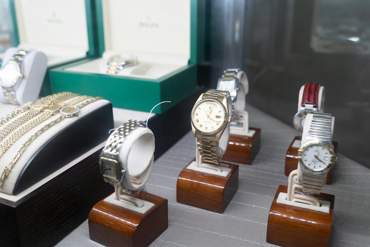 Luxury watches and gold jewelry displayed in a retail store.